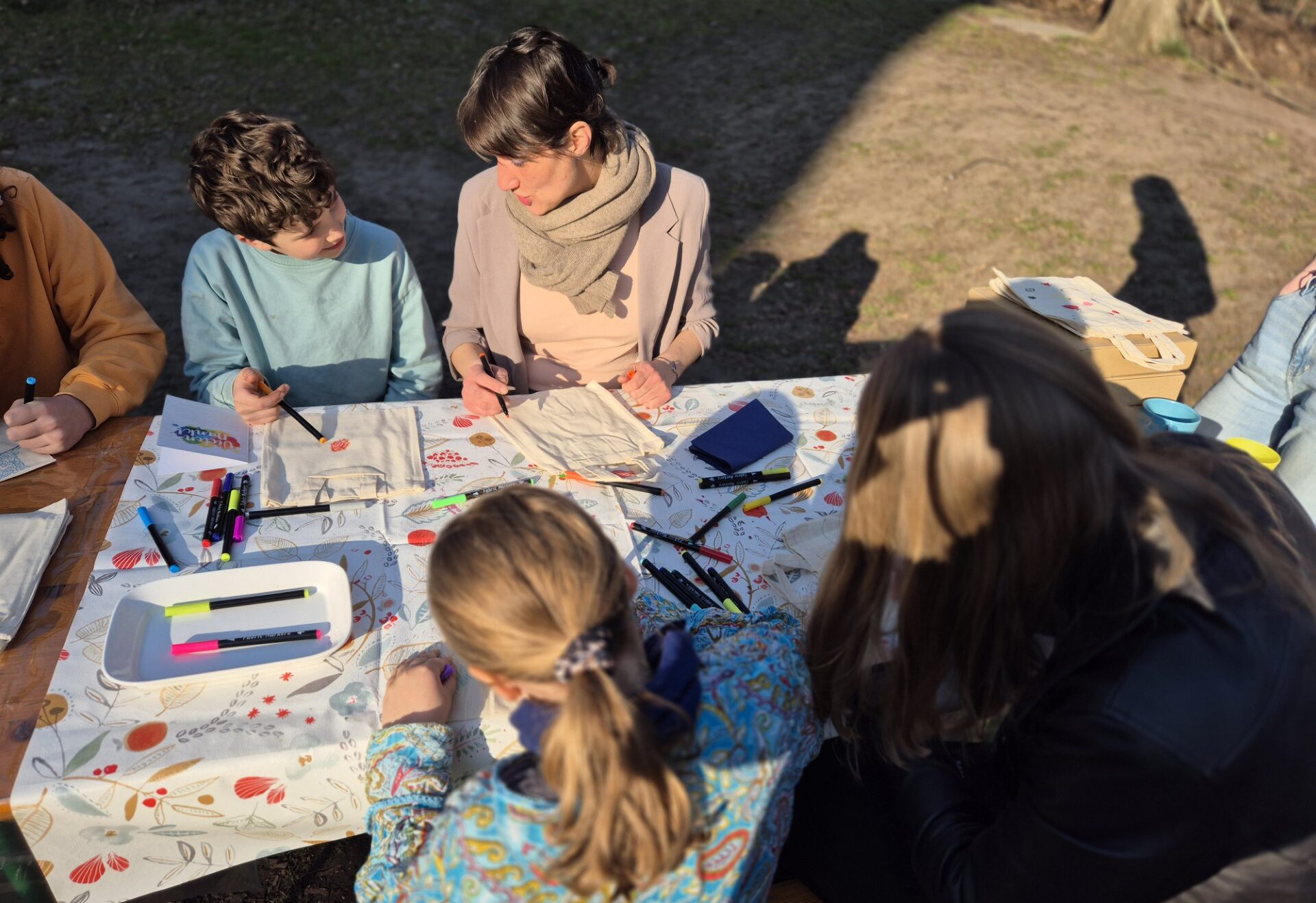 Erwachsene und Kinder basteln gemeinsam bei sonnigem Wetter während des Single Parents Day 2026.