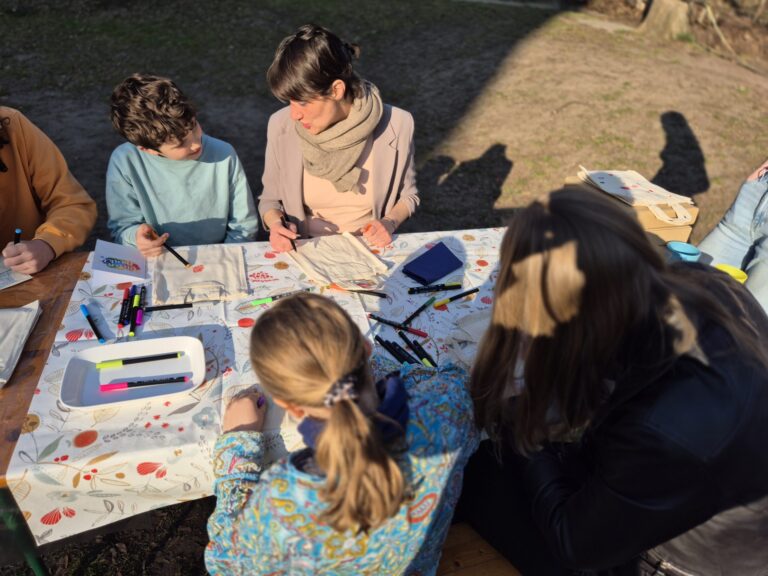 Erwachsene und Kinder basteln gemeinsam bei sonnigem Wetter während des Single Parents Day 2026.